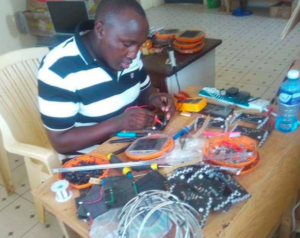 John, repairing some broken Mwezi solar lights.