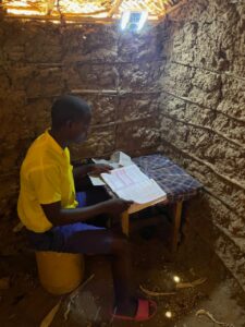 A student using a Mwezi solar light to study.